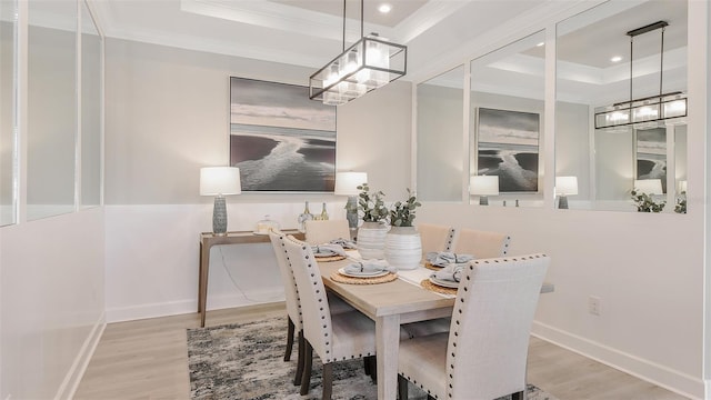 dining space featuring hardwood / wood-style floors, a tray ceiling, and crown molding