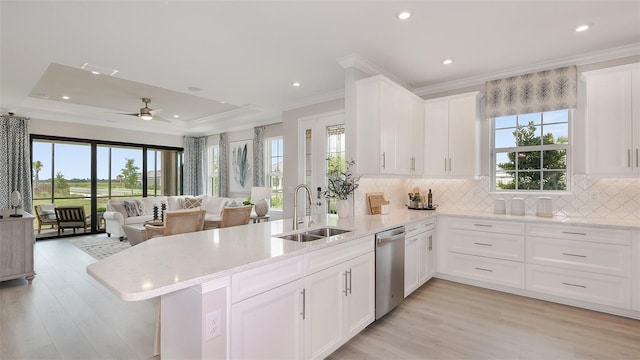 kitchen with kitchen peninsula, stainless steel dishwasher, plenty of natural light, and sink