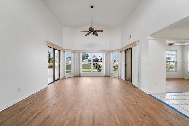 unfurnished living room with ceiling fan, light hardwood / wood-style floors, and high vaulted ceiling