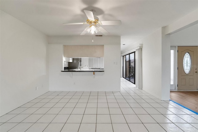 unfurnished living room featuring ceiling fan and light wood-type flooring