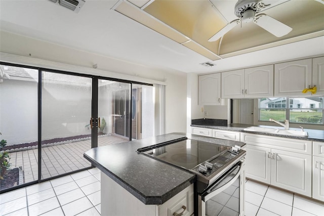 kitchen with ceiling fan, white cabinetry, sink, light tile patterned floors, and appliances with stainless steel finishes