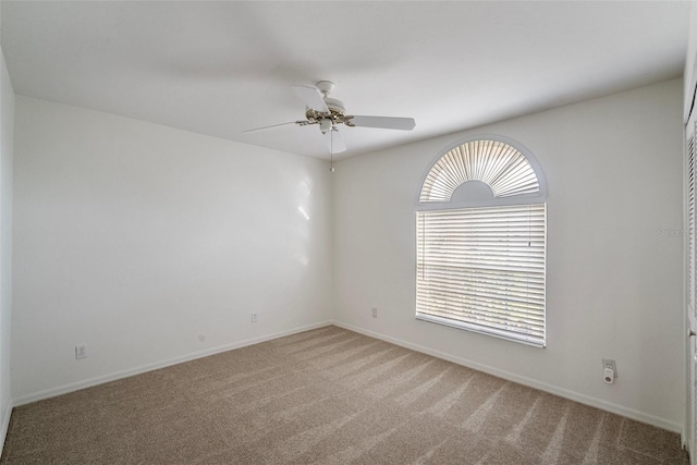 carpeted spare room with ceiling fan