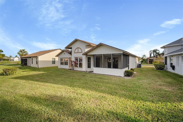 rear view of property featuring a yard, cooling unit, and a sunroom