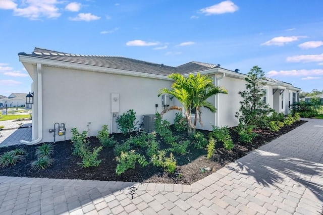 view of property exterior featuring central air condition unit and stucco siding