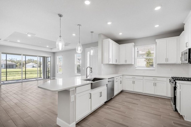 kitchen featuring a peninsula, tasteful backsplash, stainless steel appliances, and a sink