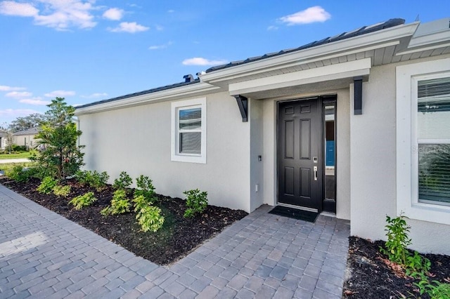 view of exterior entry featuring stucco siding