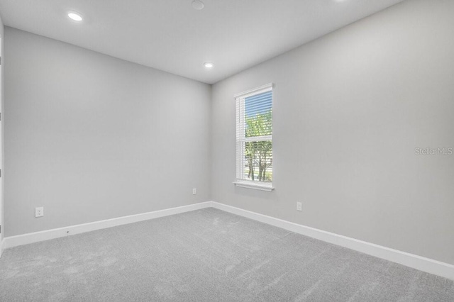 carpeted empty room featuring recessed lighting and baseboards