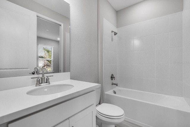 full bath with a textured wall,  shower combination, vanity, and toilet