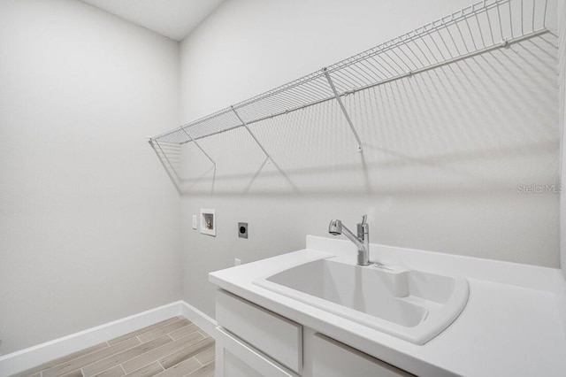 laundry room with washer hookup, a sink, cabinet space, wood tiled floor, and electric dryer hookup