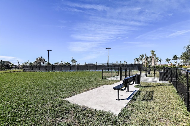 view of community with fence and a lawn