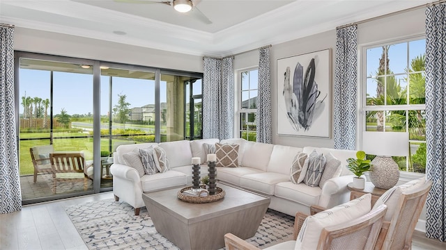 sunroom with a raised ceiling and ceiling fan