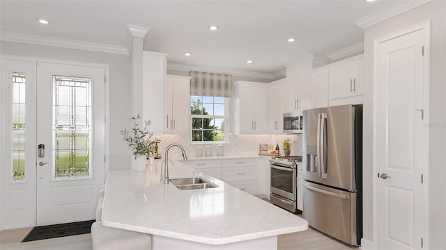 kitchen with sink, crown molding, white cabinetry, stainless steel appliances, and kitchen peninsula