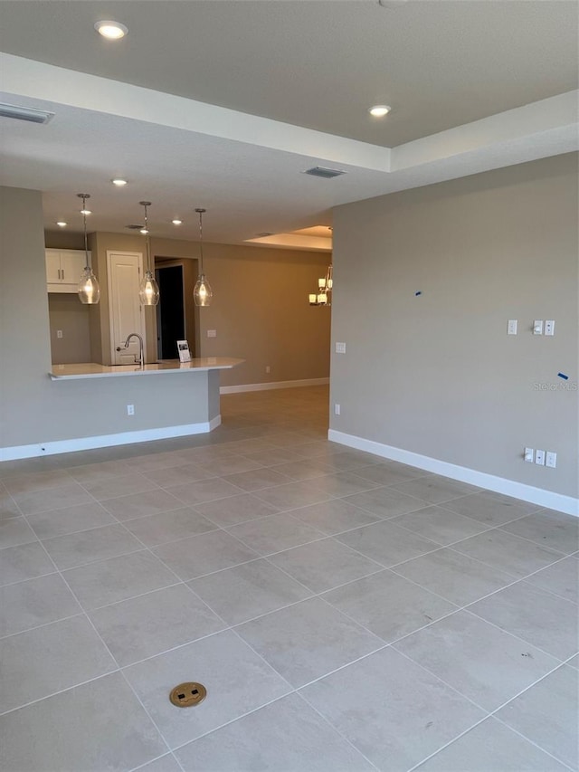 unfurnished living room with light tile patterned flooring and sink