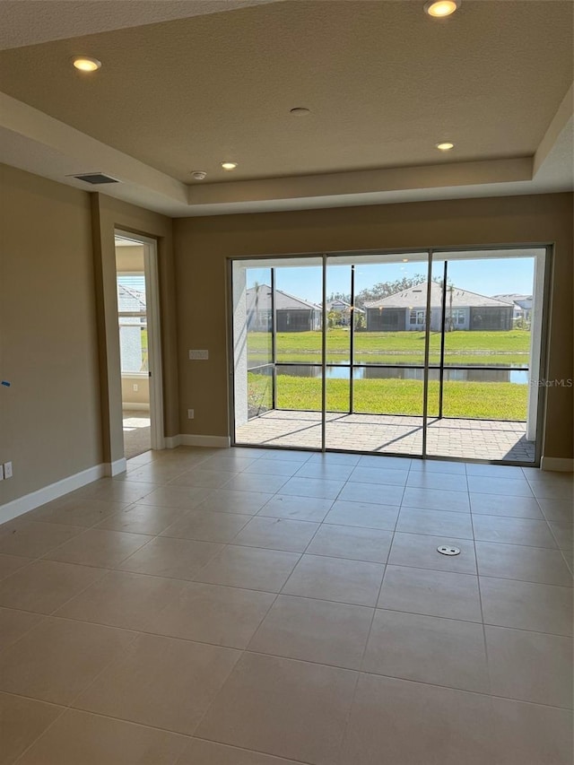 tiled spare room with a water view