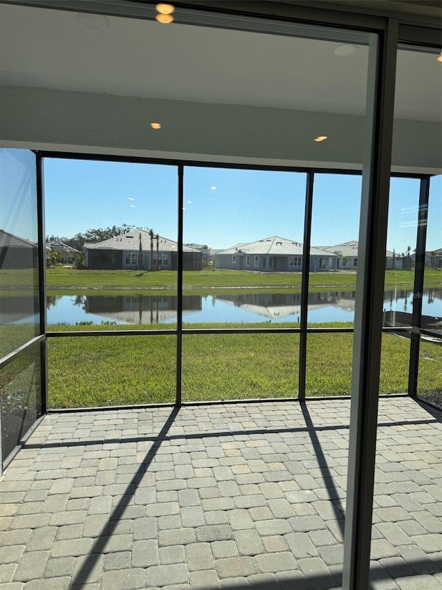 unfurnished sunroom featuring a water view