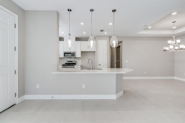 kitchen with decorative backsplash, stainless steel appliances, light countertops, white cabinetry, and a sink