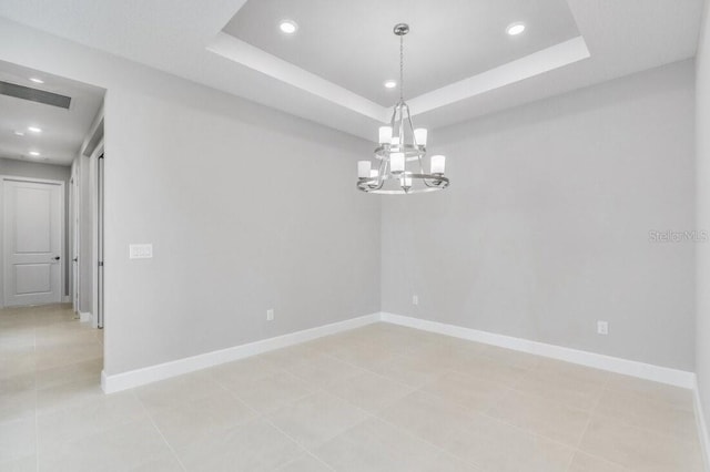 empty room with baseboards, visible vents, a tray ceiling, and recessed lighting