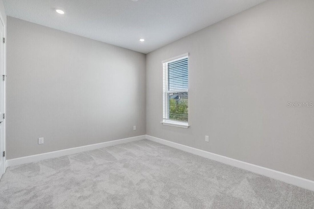 unfurnished room featuring recessed lighting, baseboards, and light colored carpet