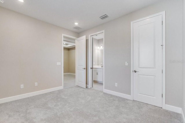 unfurnished bedroom with baseboards, visible vents, carpet flooring, and ensuite bathroom