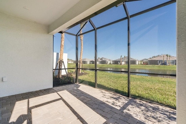 unfurnished sunroom featuring a water view