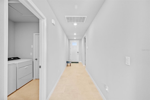 hall with light tile patterned flooring and independent washer and dryer