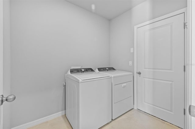 laundry area with washer and dryer and light tile patterned floors