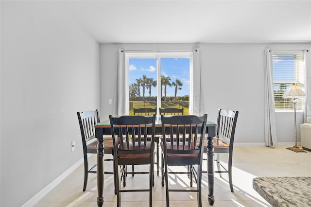 tiled dining space featuring a healthy amount of sunlight