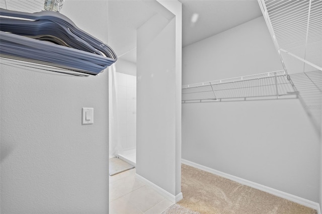 walk in closet featuring light colored carpet