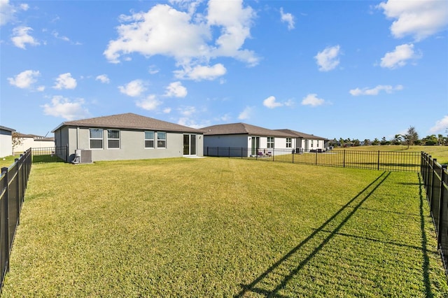 back of property with a yard and central AC