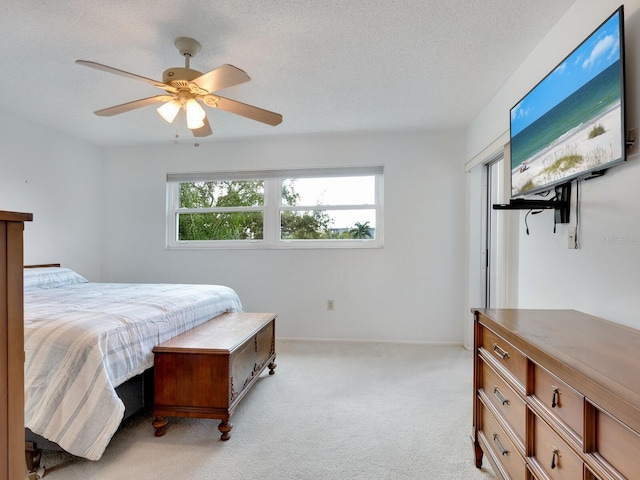 carpeted bedroom featuring a textured ceiling and ceiling fan