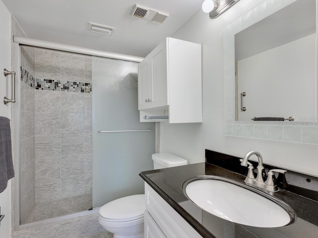 bathroom featuring walk in shower, tile patterned floors, vanity, and toilet