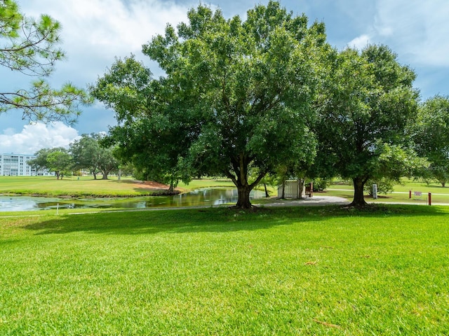 view of home's community featuring a lawn and a water view