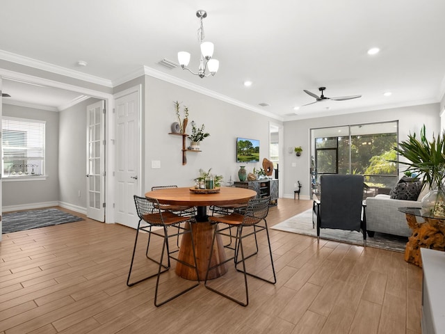 dining room featuring a healthy amount of sunlight, ceiling fan with notable chandelier, and light hardwood / wood-style floors