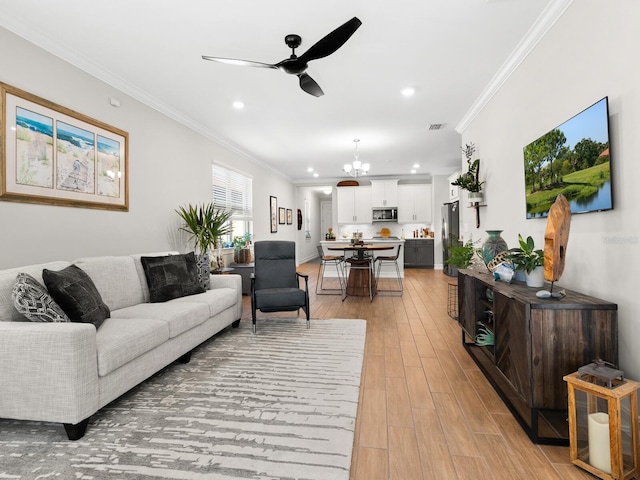 living room with light hardwood / wood-style floors, ceiling fan with notable chandelier, and ornamental molding