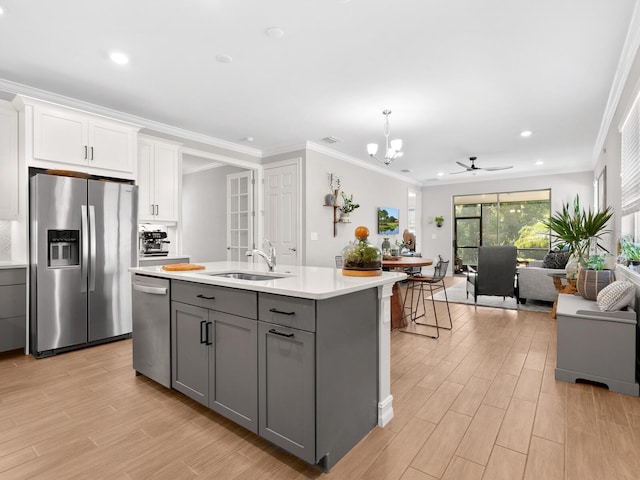 kitchen featuring gray cabinetry, white cabinets, ceiling fan with notable chandelier, sink, and stainless steel appliances