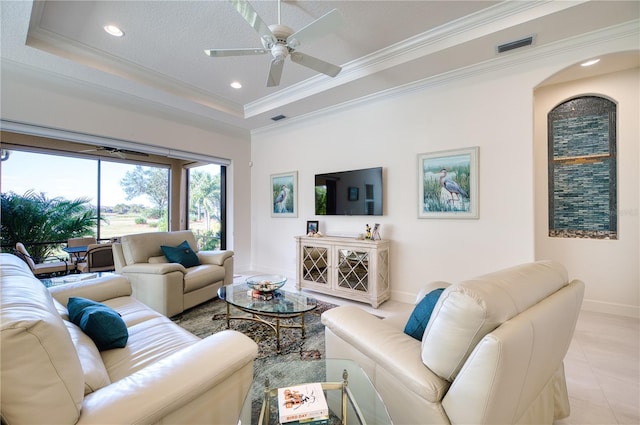 tiled living room with a textured ceiling, a raised ceiling, and crown molding