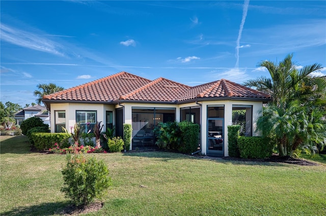 mediterranean / spanish home with a sunroom and a front yard