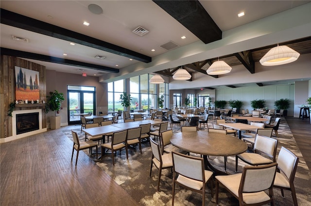 dining area with beamed ceiling and dark wood-type flooring