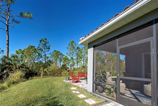 view of yard with a sunroom and a patio area