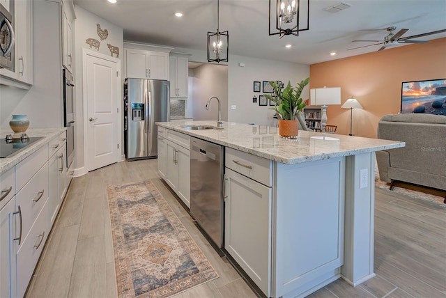 kitchen featuring white cabinetry, sink, an island with sink, pendant lighting, and appliances with stainless steel finishes