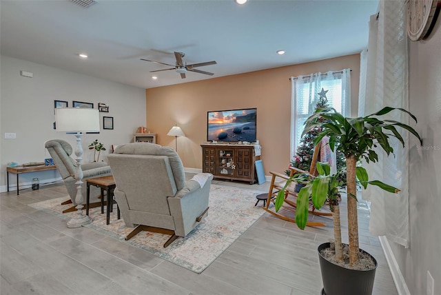 living room featuring ceiling fan and light wood-type flooring