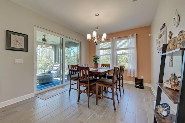 dining space featuring ceiling fan with notable chandelier, light hardwood / wood-style floors, and a healthy amount of sunlight