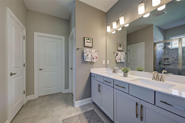 bathroom with a shower with door, vanity, and tile patterned flooring