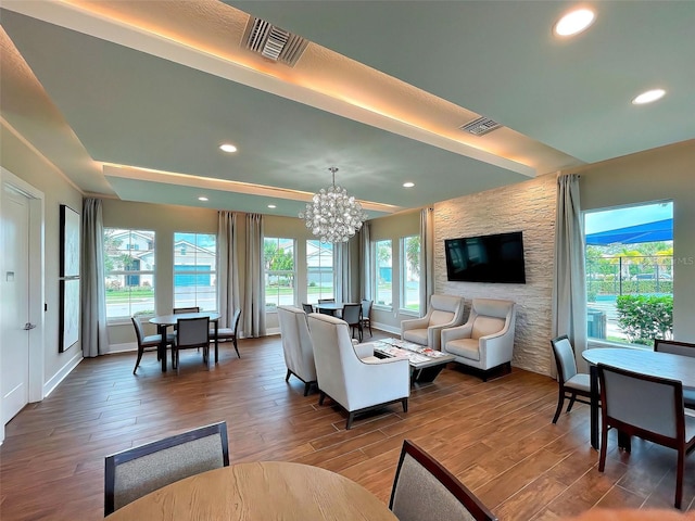 living room with hardwood / wood-style flooring, a healthy amount of sunlight, and a notable chandelier