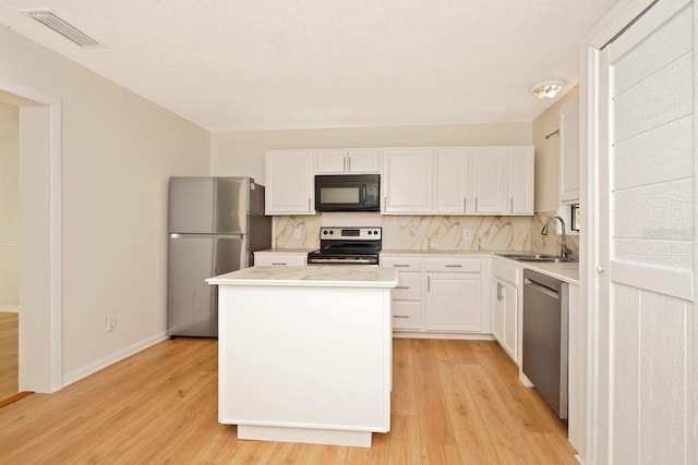 kitchen featuring white cabinets, stainless steel appliances, light hardwood / wood-style flooring, and sink