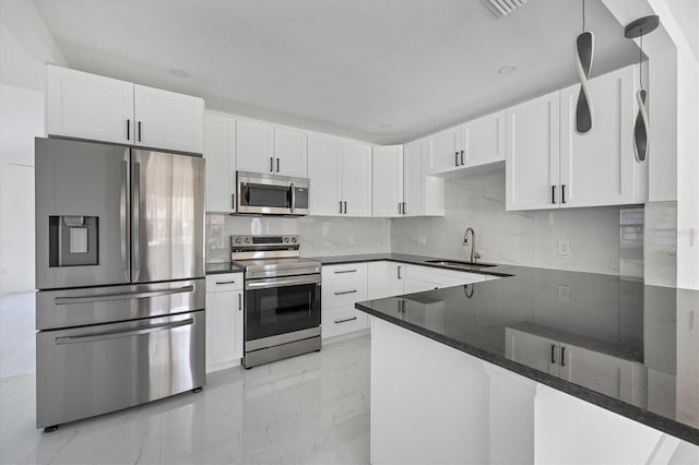 kitchen featuring white cabinets, stainless steel appliances, dark stone counters, and sink