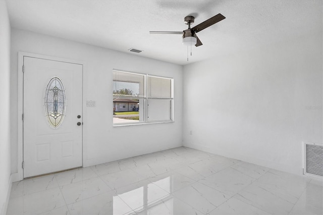 entryway featuring ceiling fan and a textured ceiling