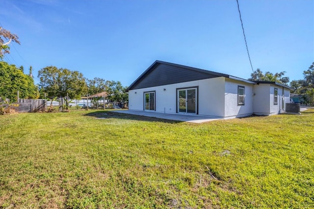 back of property featuring a patio, a lawn, and central air condition unit