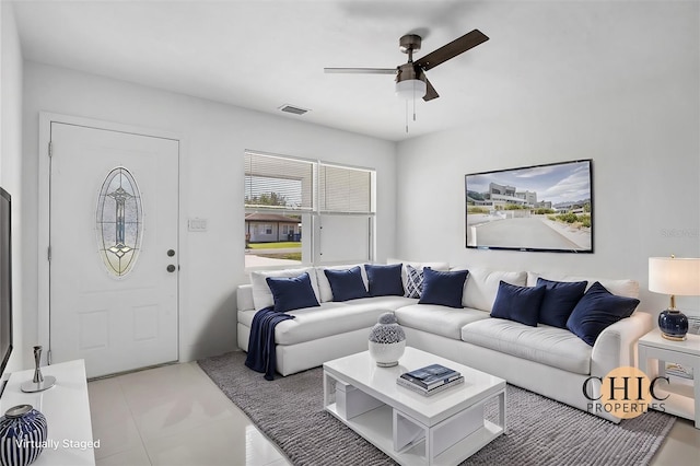 living room with ceiling fan and tile patterned floors