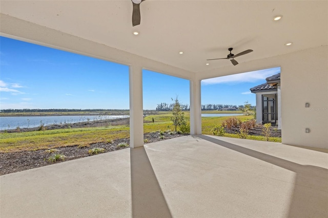 view of patio / terrace featuring a water view and ceiling fan